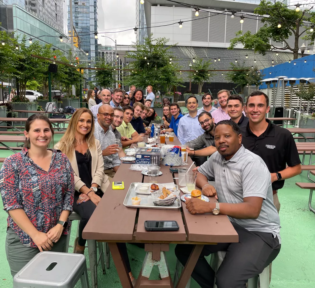 Clark team members gather for lunch around an outdoor table