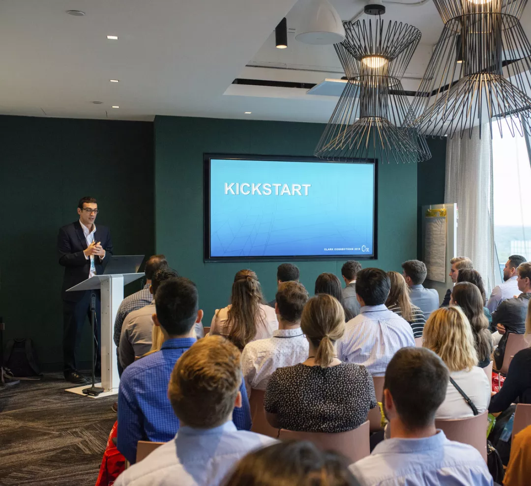 Brian Krause of Clark Construction stands in front of a seated crowd to lead a presentation